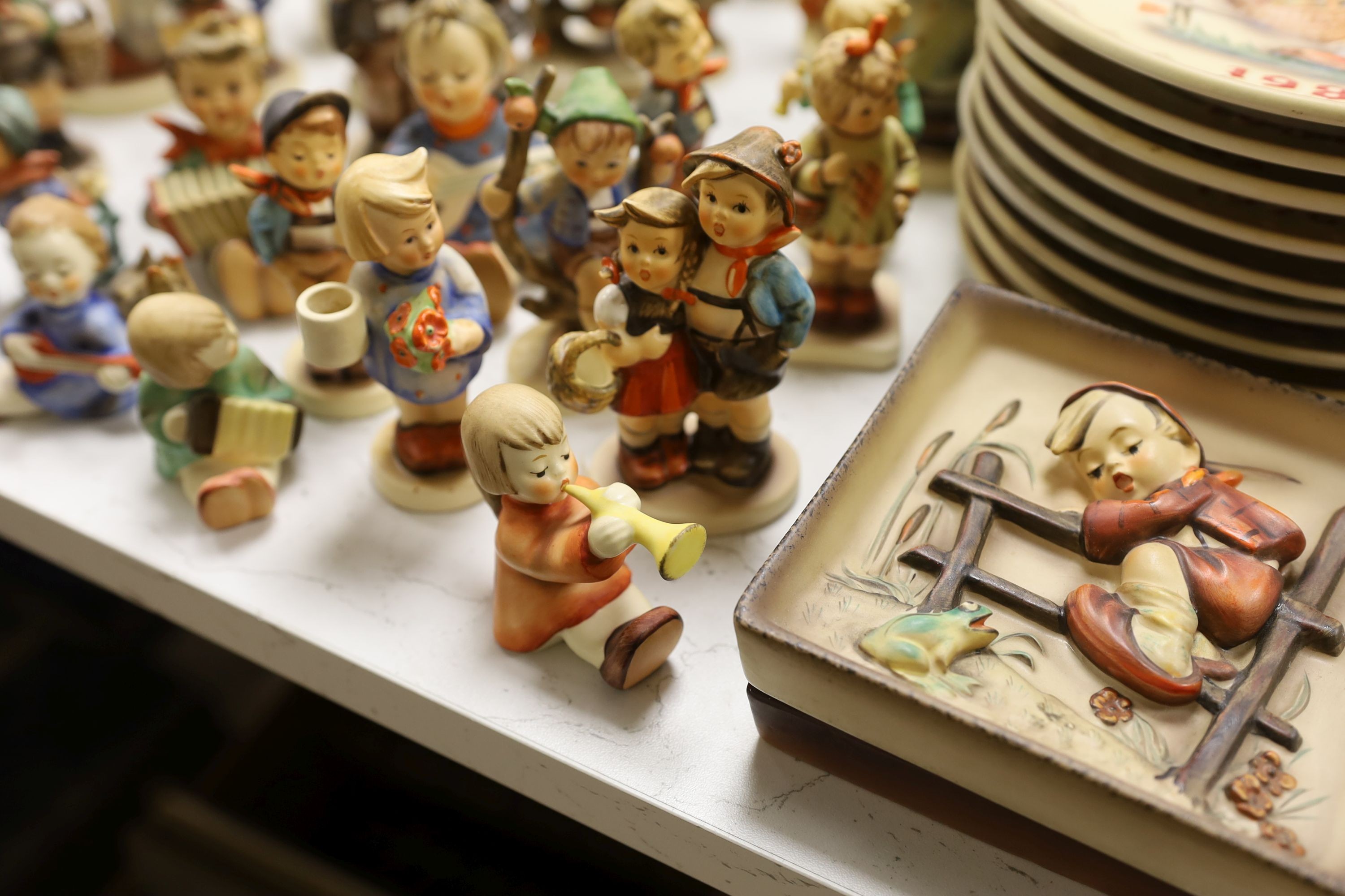 A large collection of Hummel pottery figures, approximately 70 including skier and two similar plaques, some with boxes.